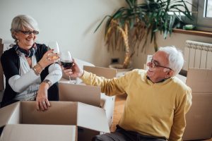 Happy senior couple taking a break and drinking wine Retirees downsizing to a new home